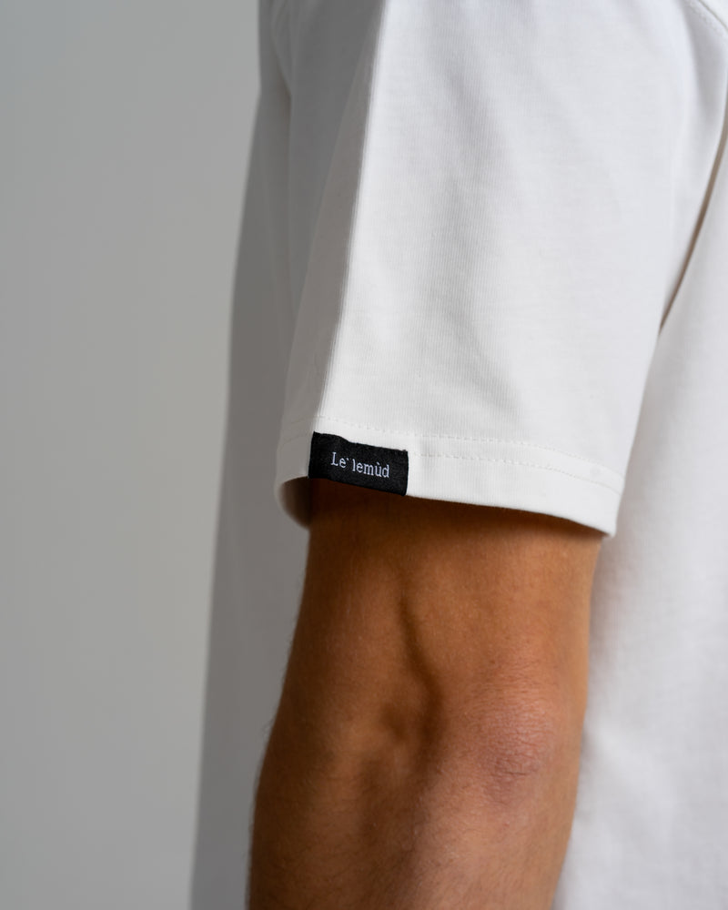 White oversized t-shirt with Le lemud woven sleeve label, front view on white background closeup
